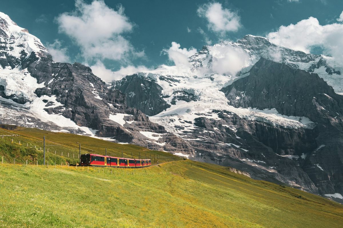 Red mountain train passing through the Swiss Alps