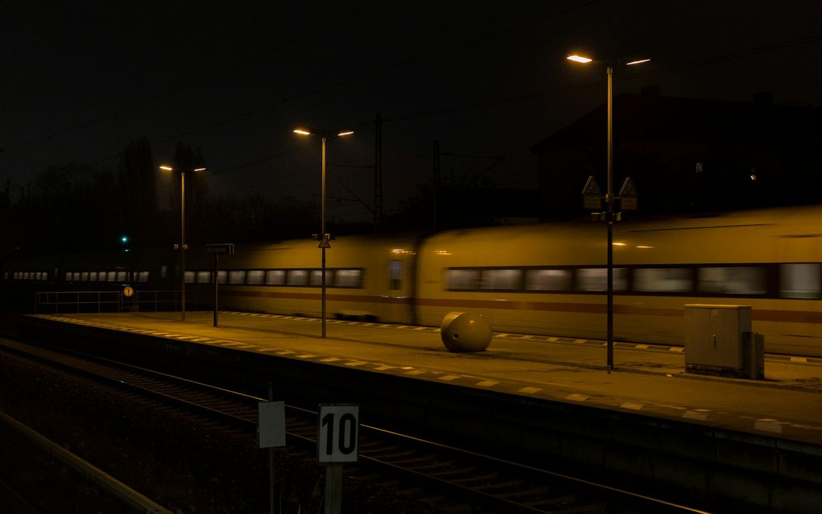 Train speeding through a station at night