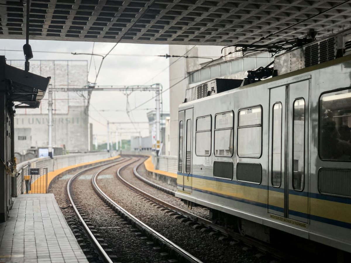 White and yellow train on rail tracks in the Philippines