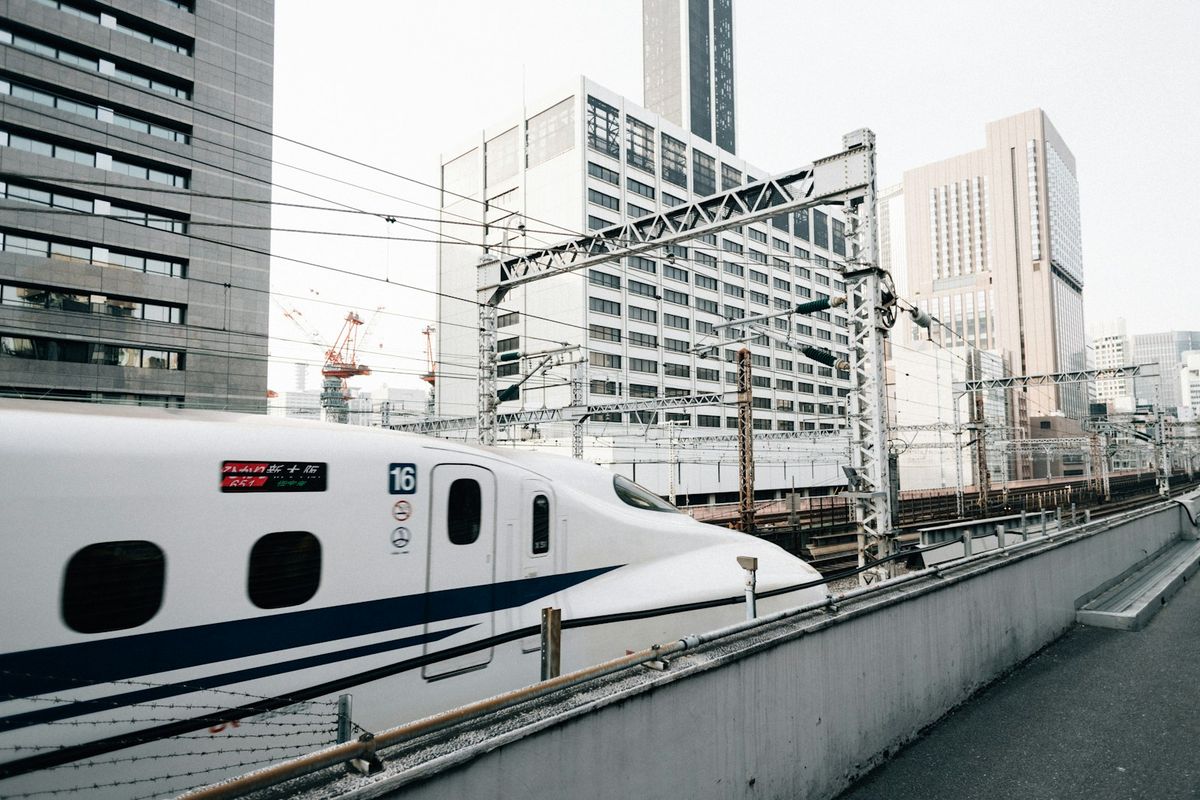 Shinkansen bullet train speeding past buildings in Japan