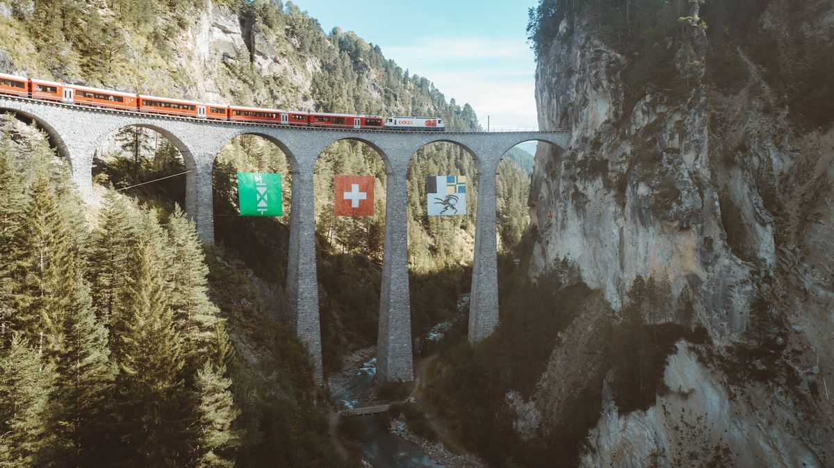 Concrete railway bridge spanning a valley in the Swiss Alps