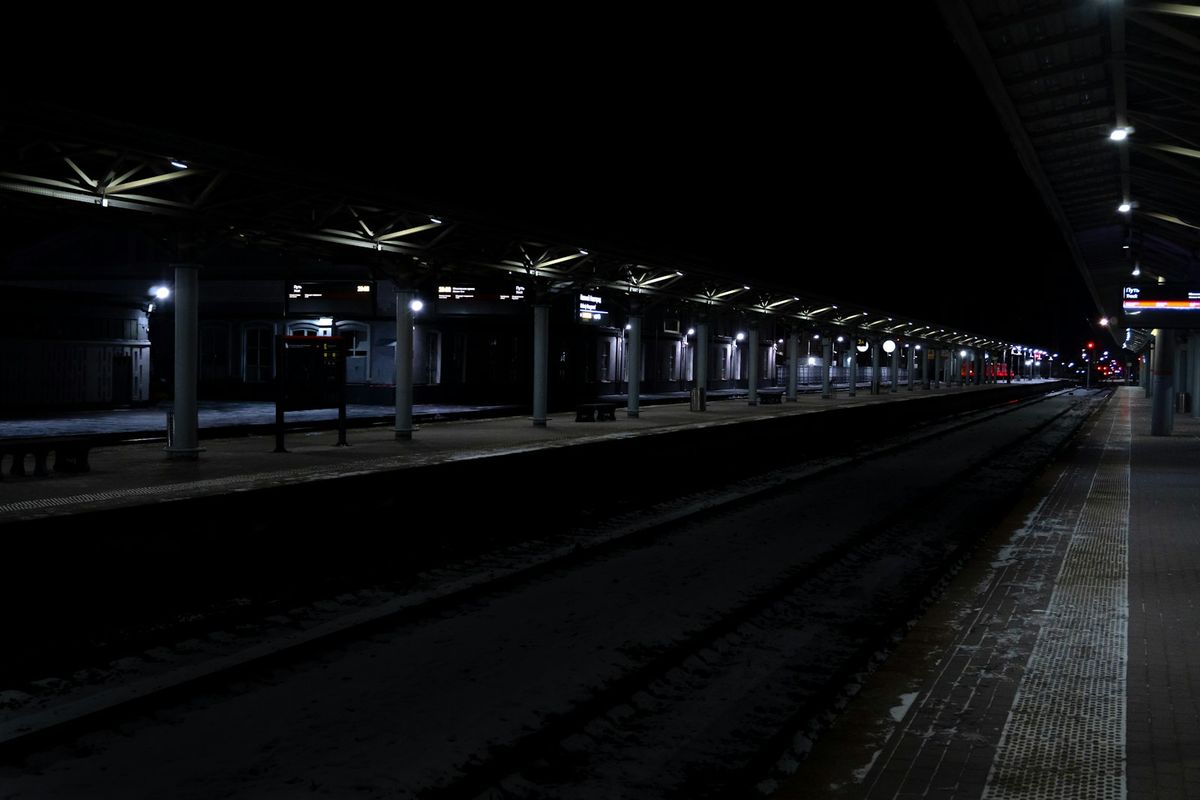 Empty train station platform illuminated at night