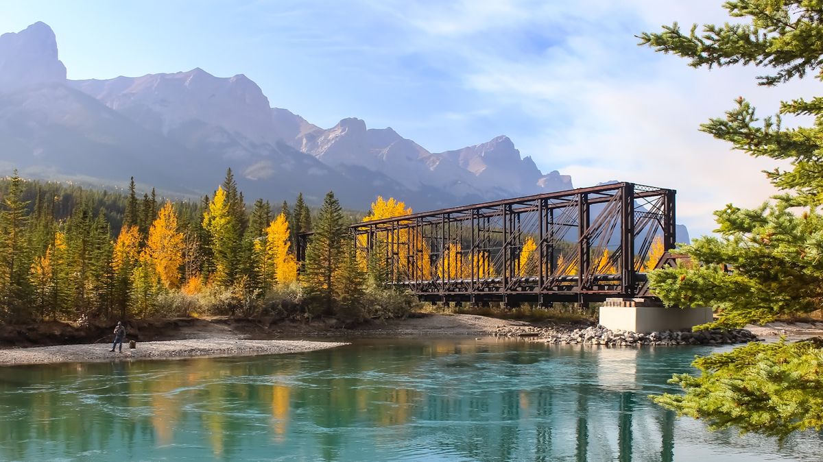 Train bridge through autumn forest and mountains in Canada