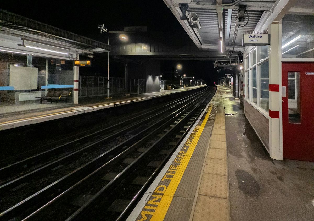 An empty railway platform at night with no trains running