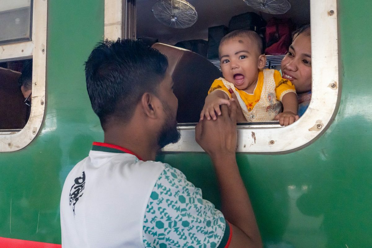 Man reaching to a baby at a train window