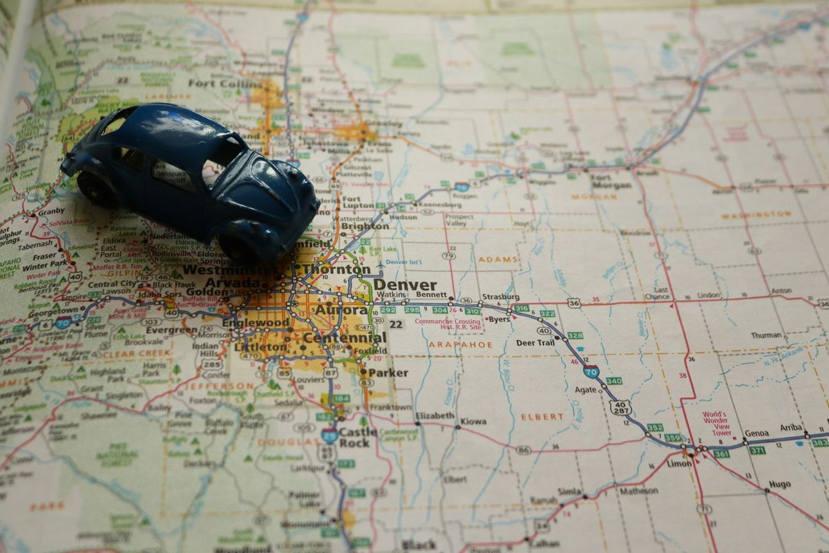 Toy car parked on a road map, symbolizing cross-border trip planning