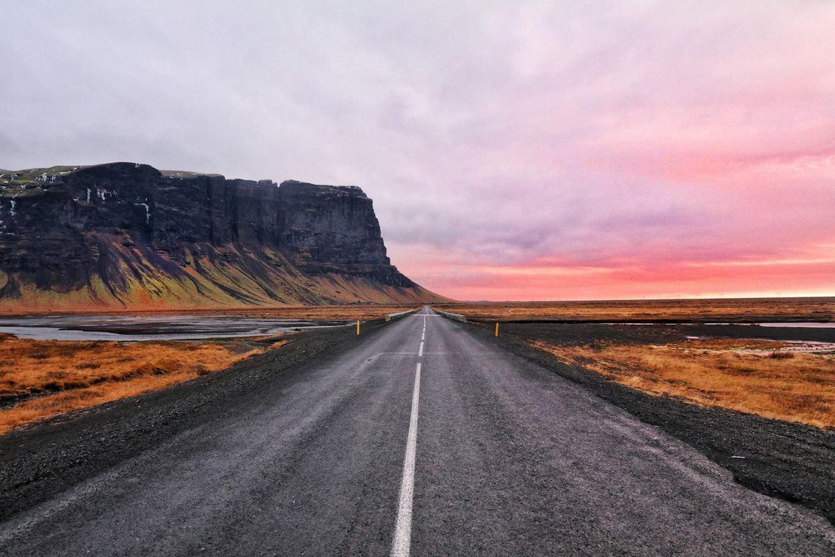 Asphalt highway with dramatic cliff formations in Iceland