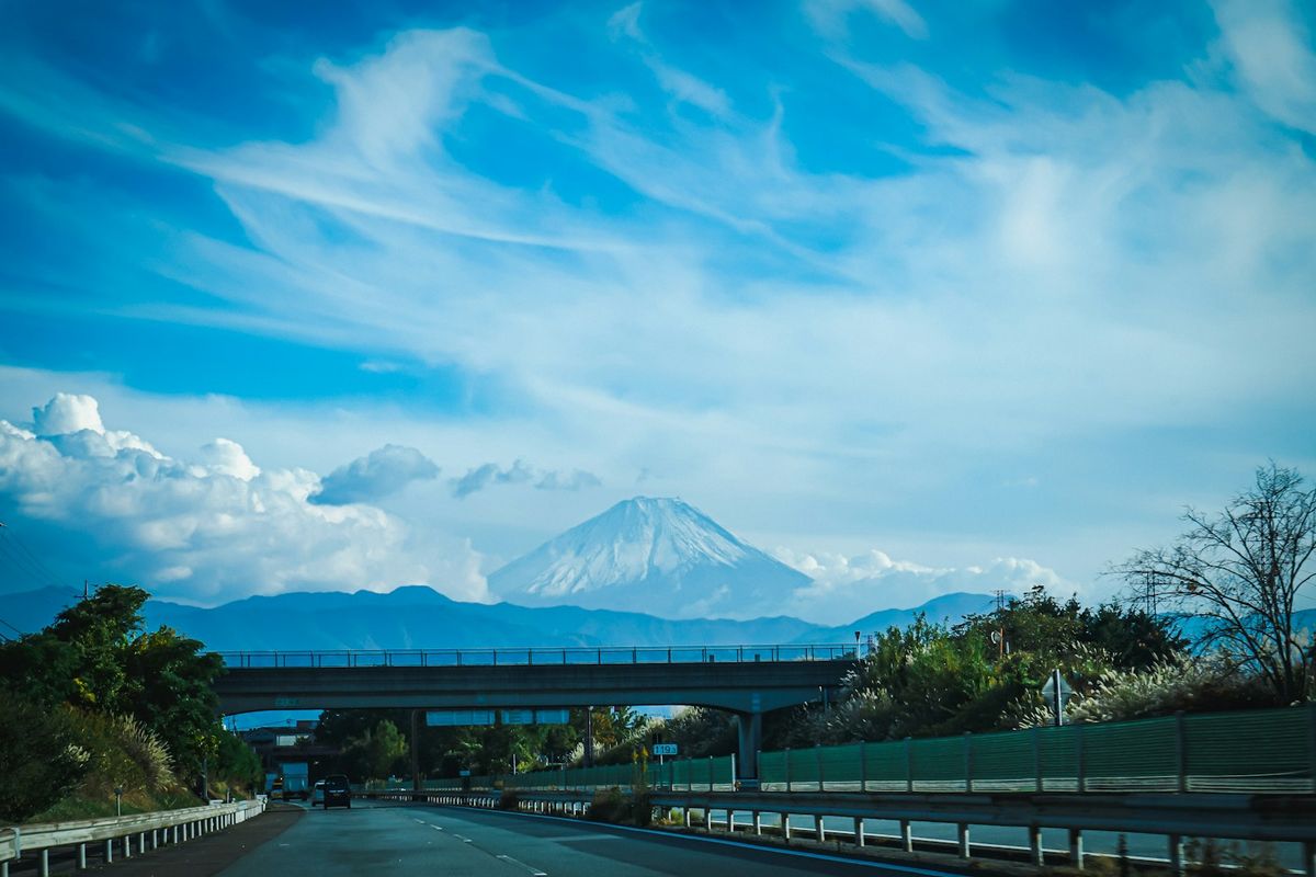 Highway with overpass bridge and Mount Fuji in the background in Japan