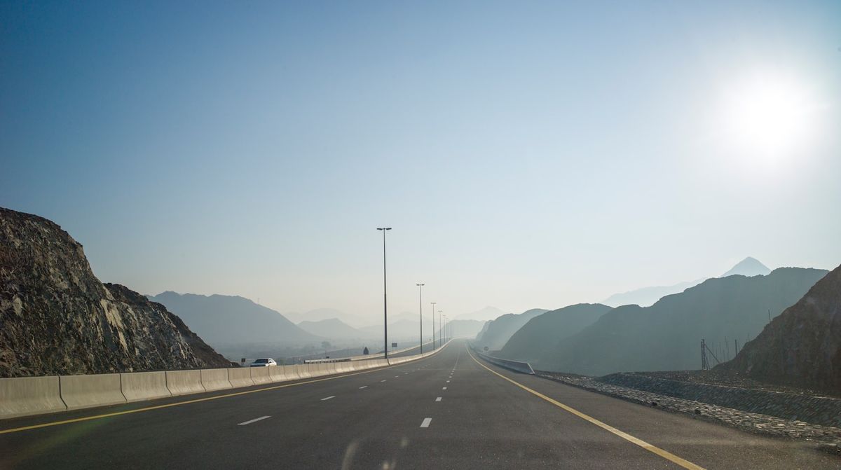 Sunlit highway through the mountains of Oman