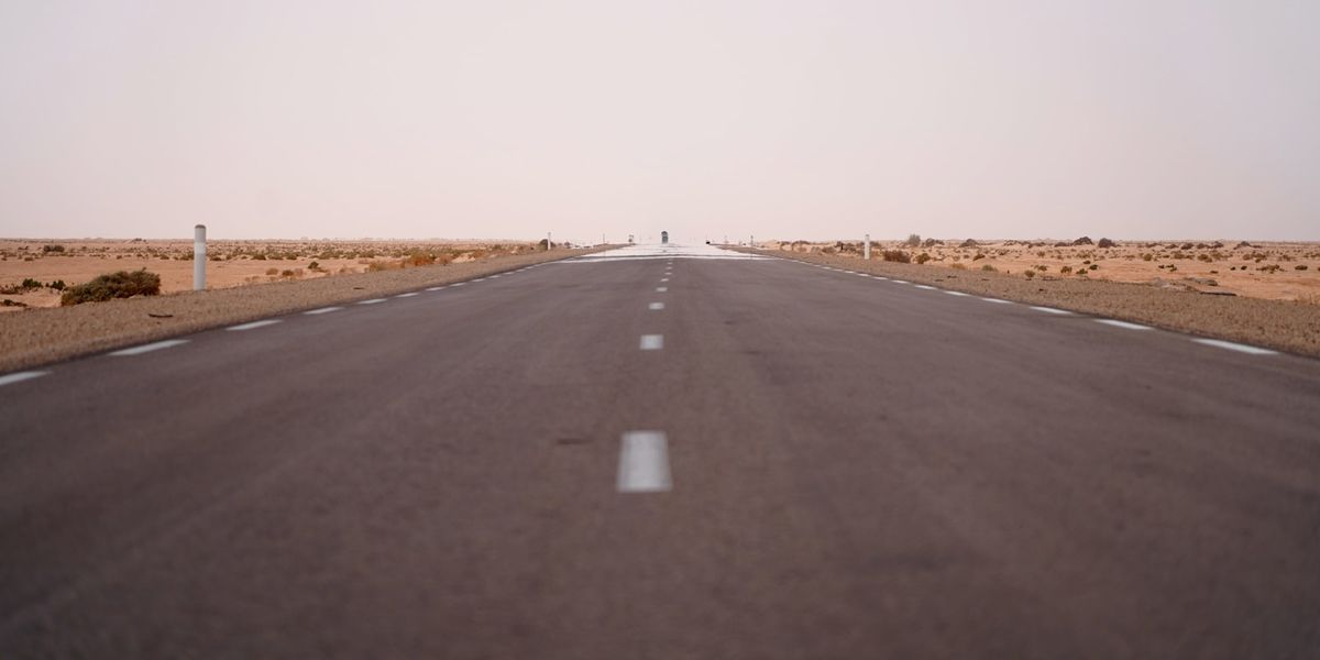 Empty road stretching through the Sahara desert in Tunisia