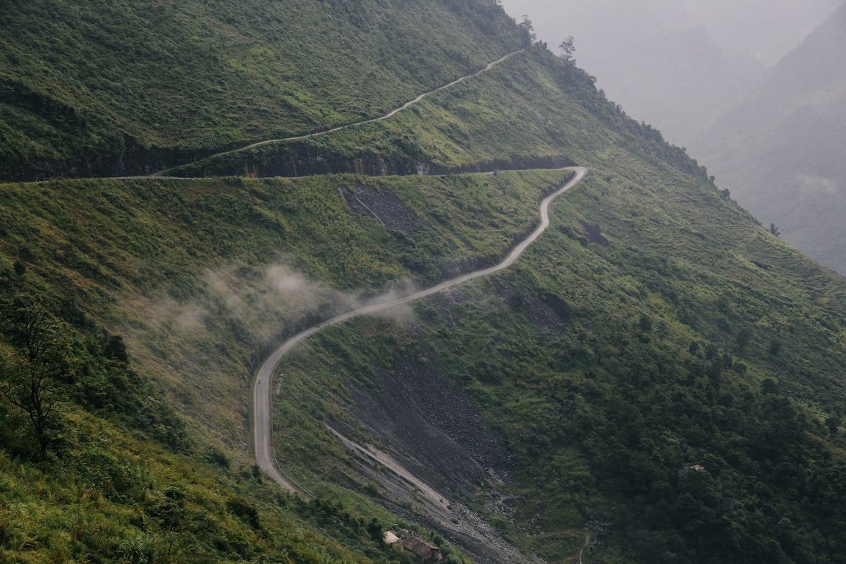 Winding road through lush green Vietnamese hillside