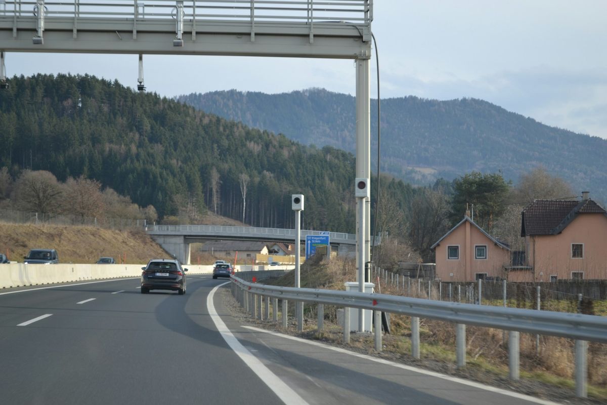 Cars on a highway with forested hills in the background