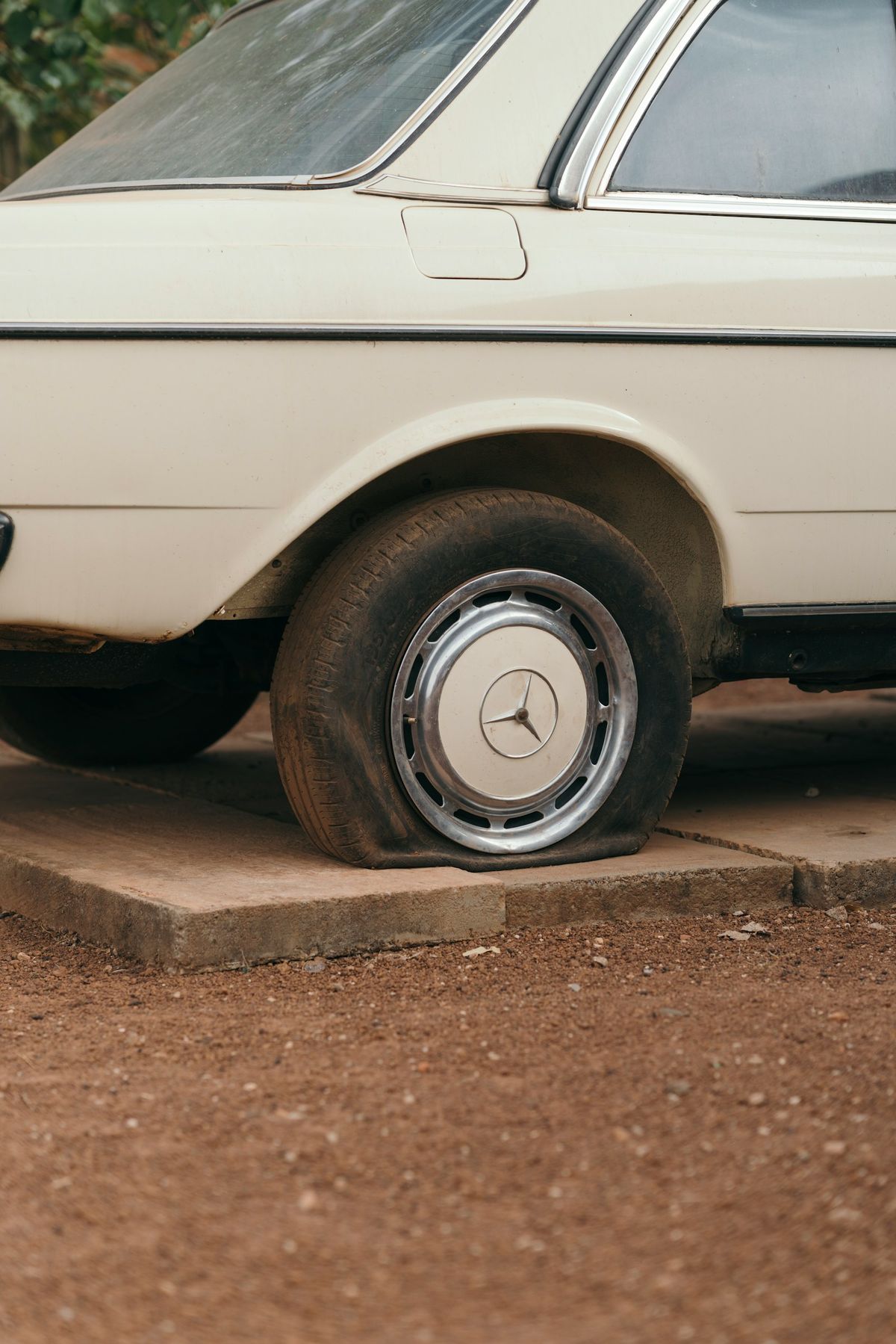 A car with a flat tyre stopped at the roadside