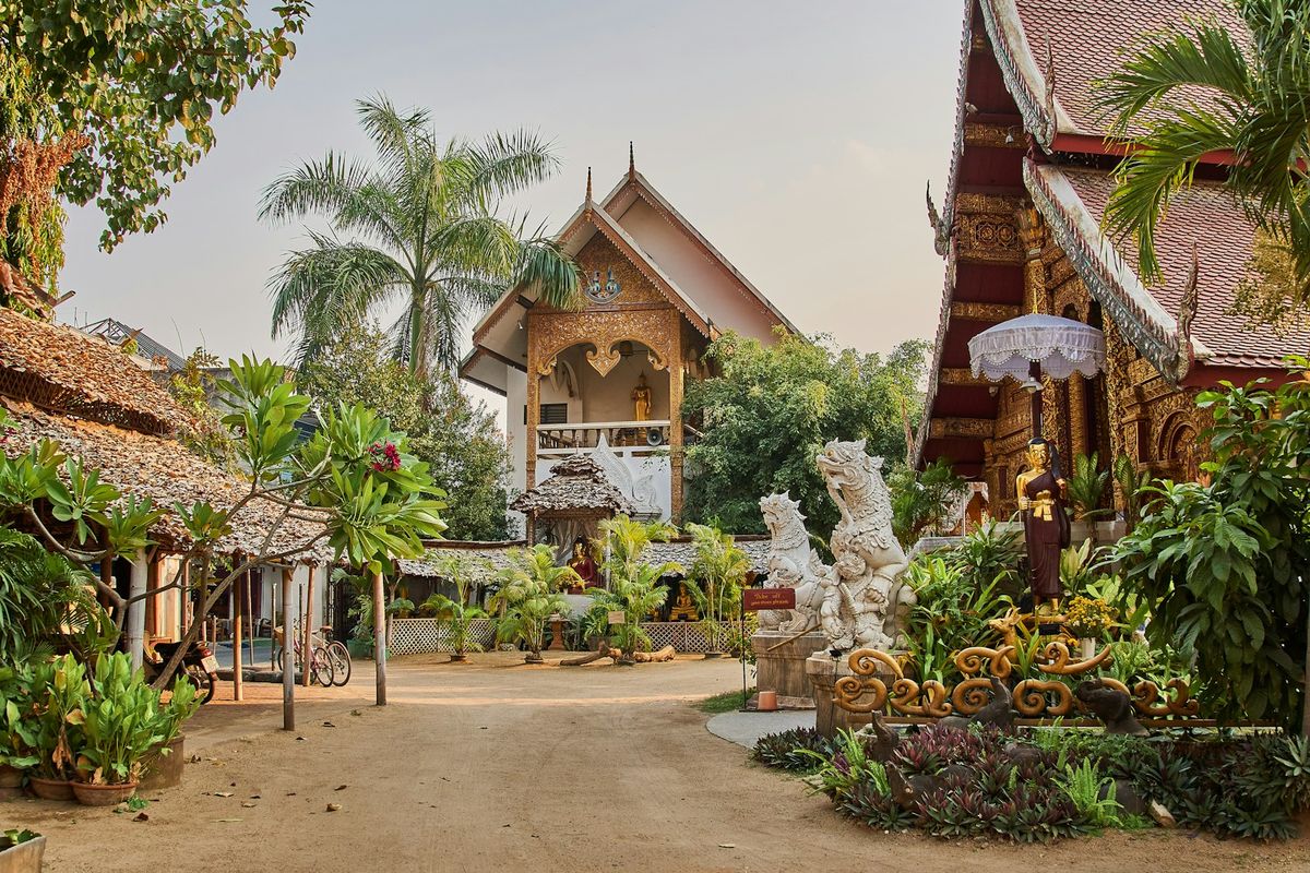 Ornate Buddhist temple surrounded by green trees in Chiang Mai Thailand
