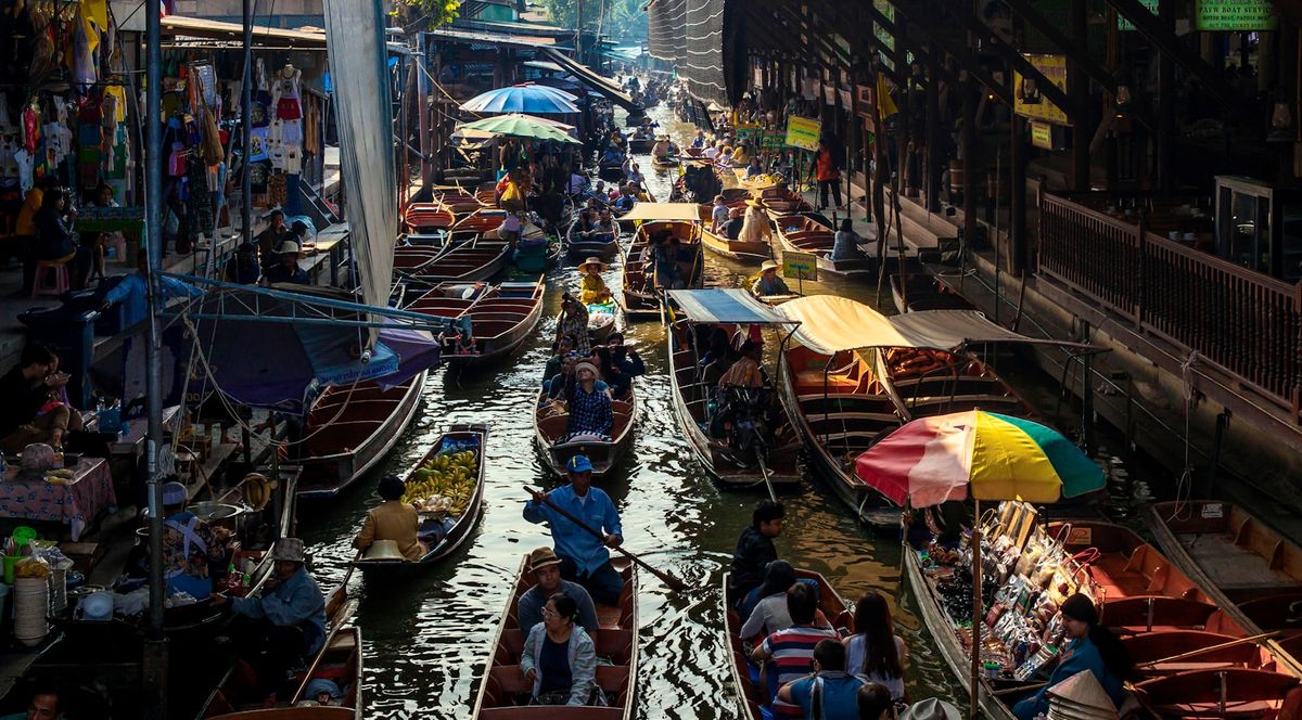 People riding boats through the Damnoen Saduak floating market near Bangkok