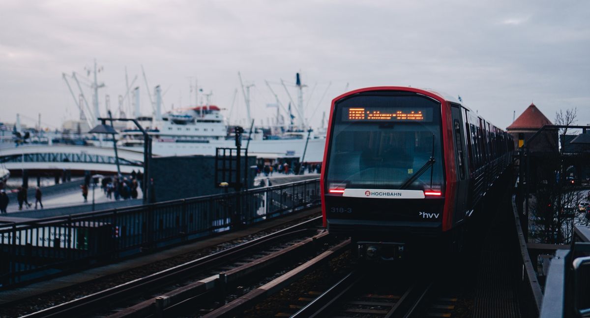Red train travelling along Hamburg harbour waterfront