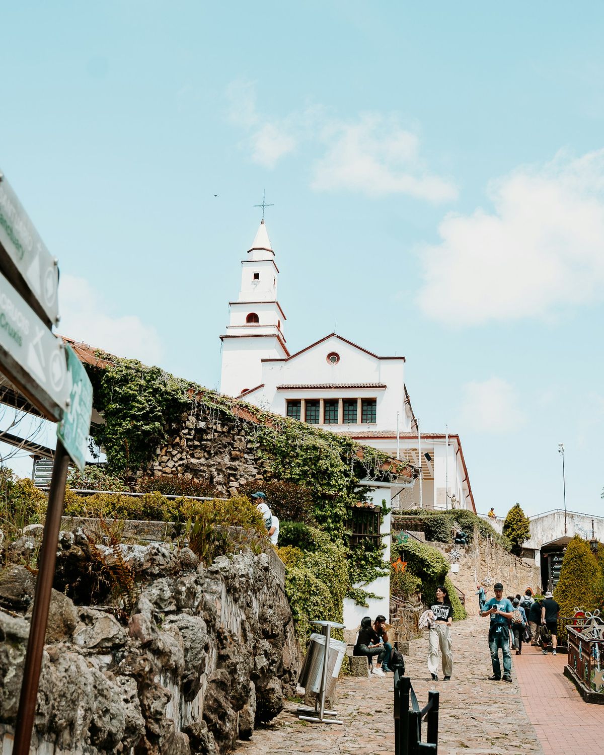 Visitors walking a stone pathway at the Monserrate sanctuary above Bogota