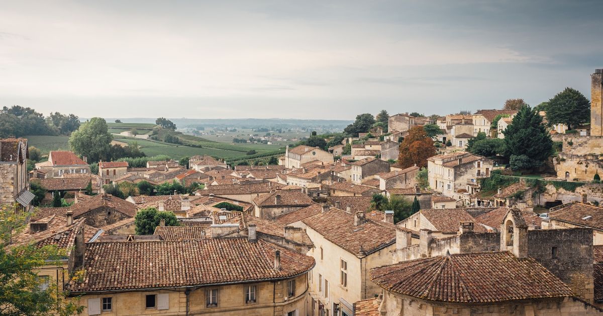 Terracotta rooftops of Saint-Emilion village amid rolling vineyards