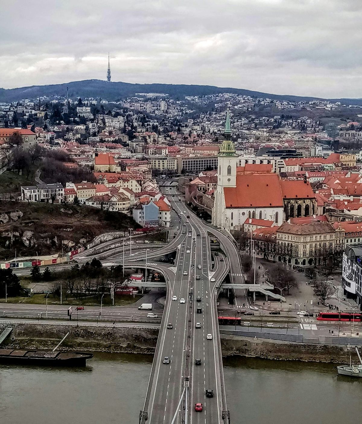 Bridge over river in Bratislava with city buildings
