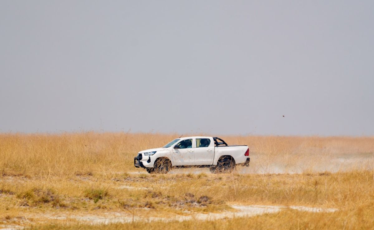 Overland truck driving through the African savanna