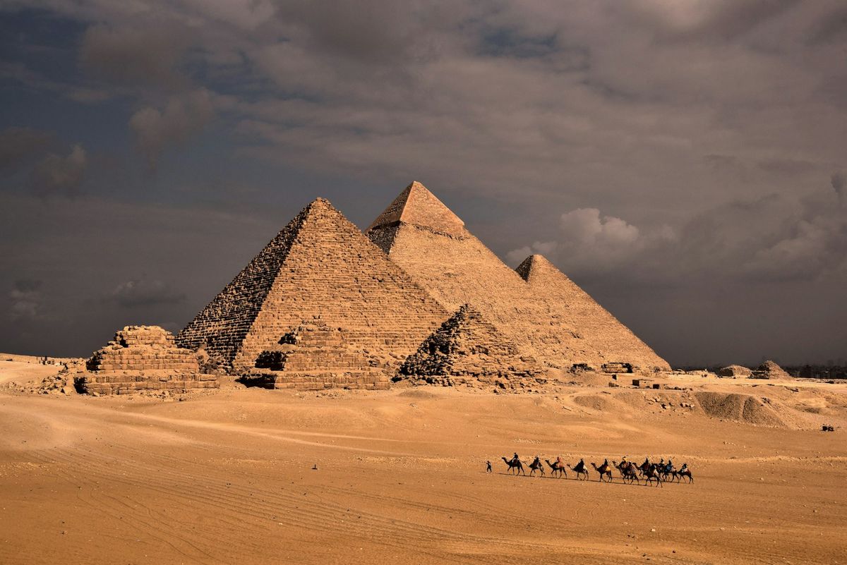 Camel riders in front of the pyramids of Giza