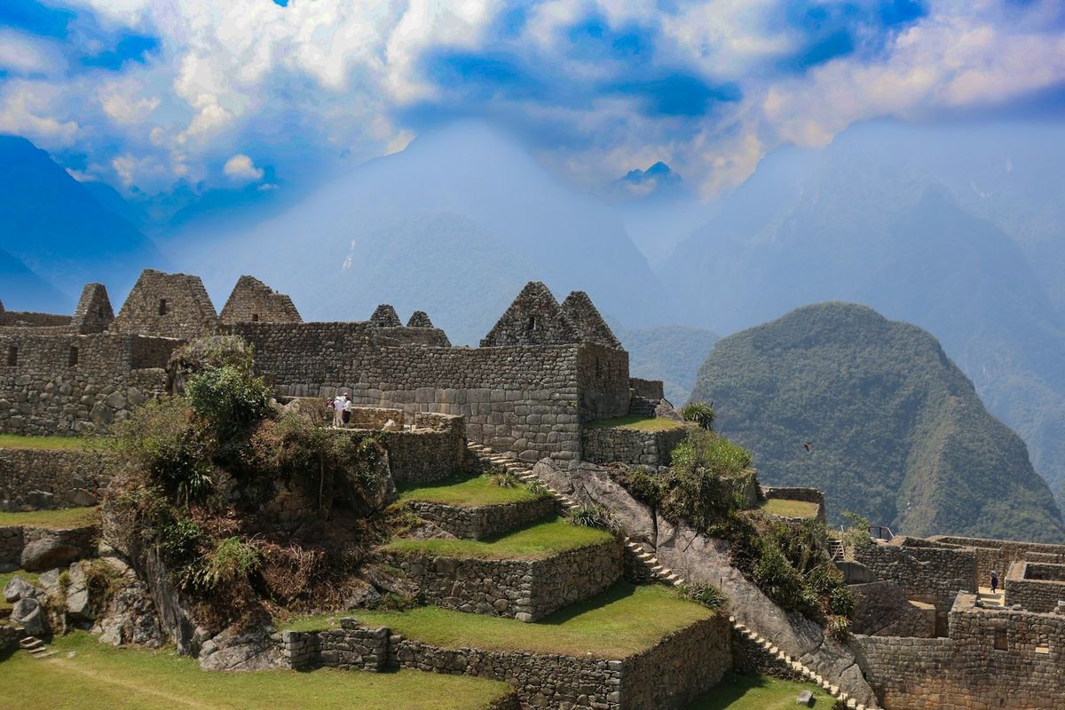 View of Incan ruins with mountain range in the background near Cusco Peru