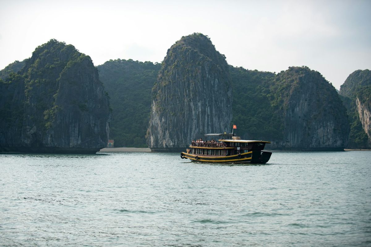 Boat near limestone karst islets in Ha Long Bay