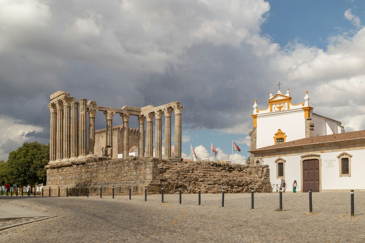 Large building with columns and clock tower in Evora, Portugal