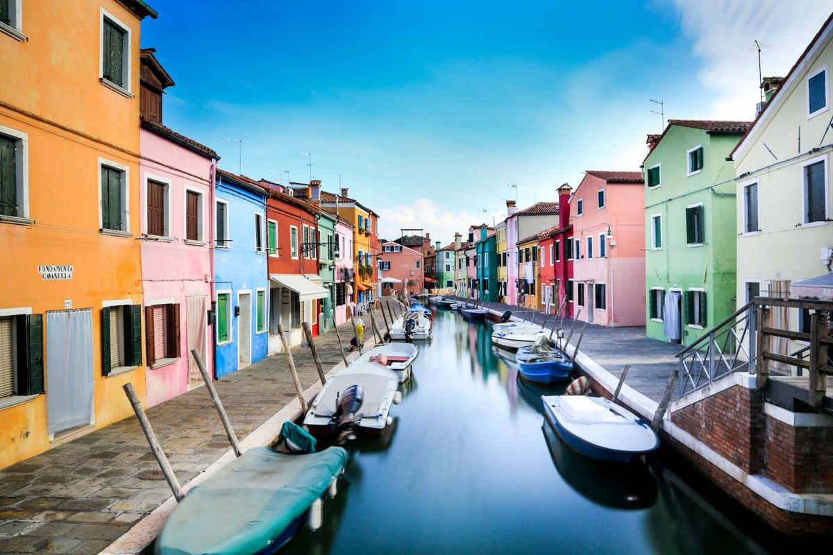 Boats on the canal between historic houses in Venice