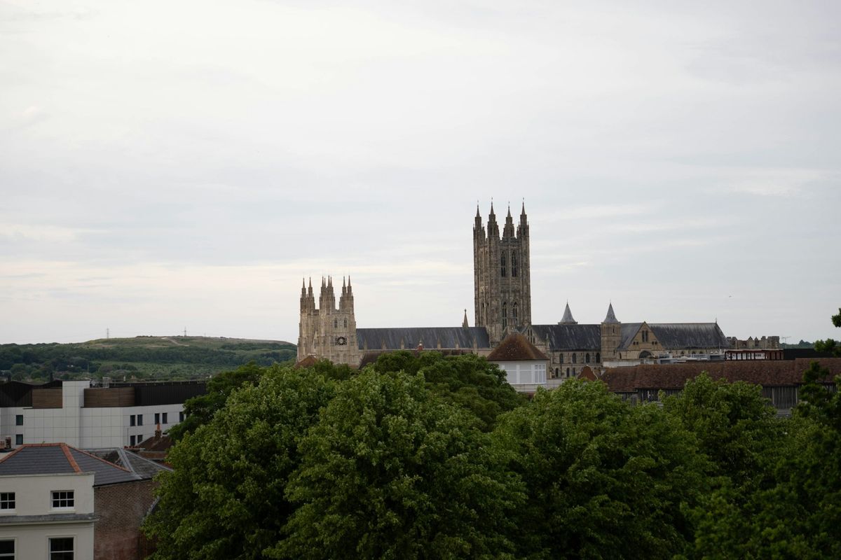 Canterbury Cathedral tower rising above green trees, England
