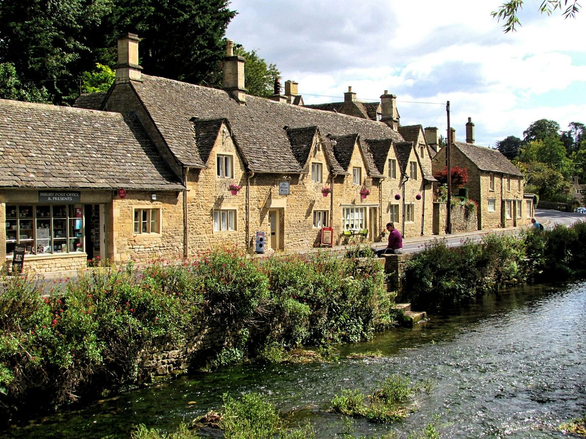 Honey-coloured stone cottages beside a stream in the Cotswolds, England