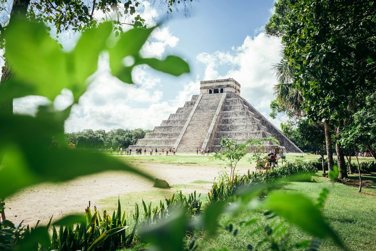 Chichen Itza Maya pyramid in a lush green field in Mexico