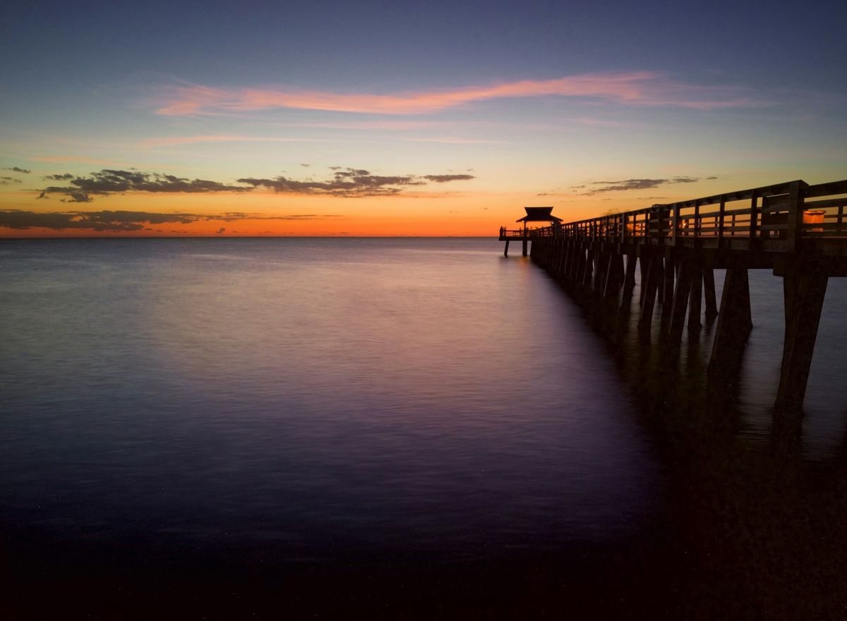 Wooden pier stretching into the ocean at sunset in the Florida Keys