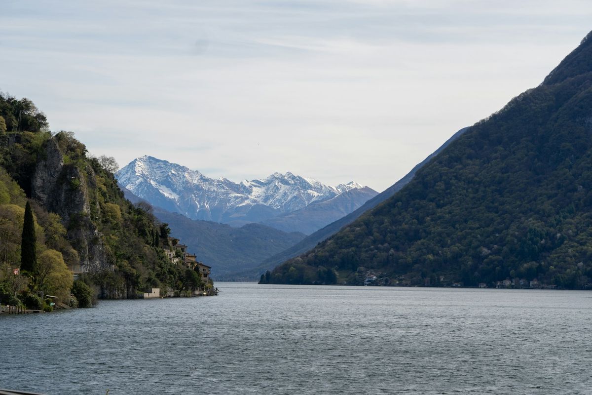 Calm mountain lake with snow-capped peaks reflected in water