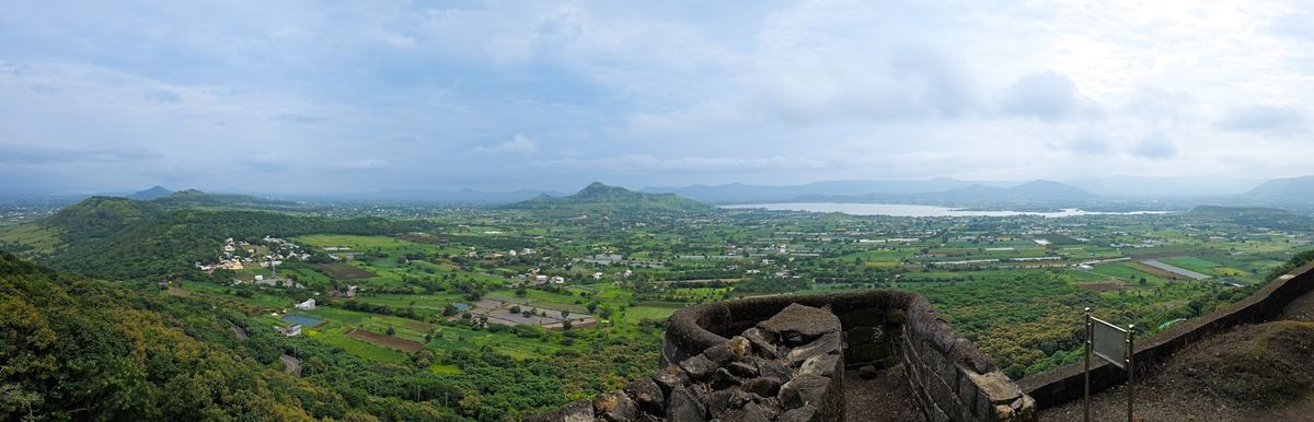 Expansive green valley with a distant lake near Lonavala, India
