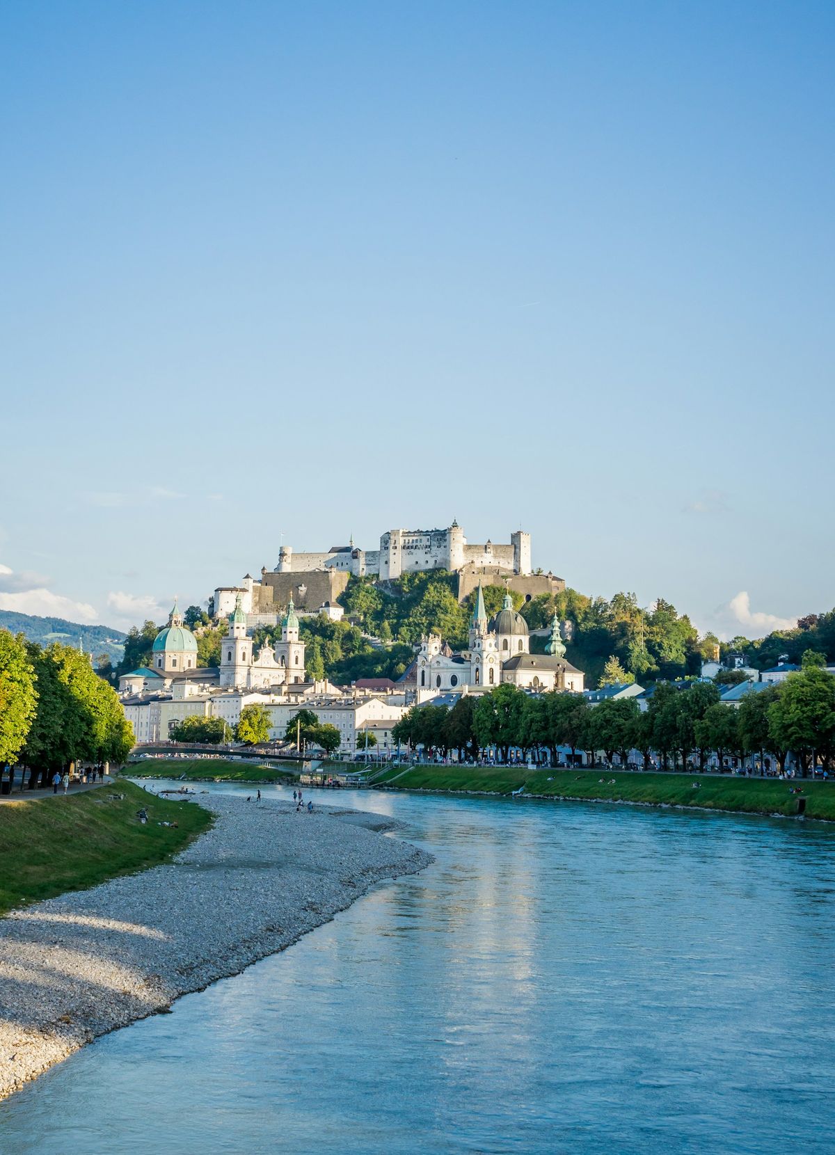 River running through Salzburg city with castle in background