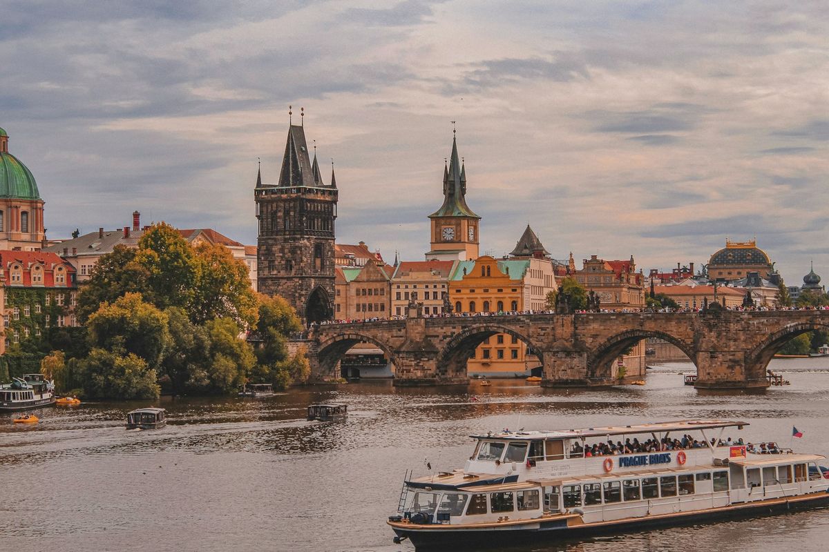 Boat on the Vltava River with Charles Bridge and Prague skyline