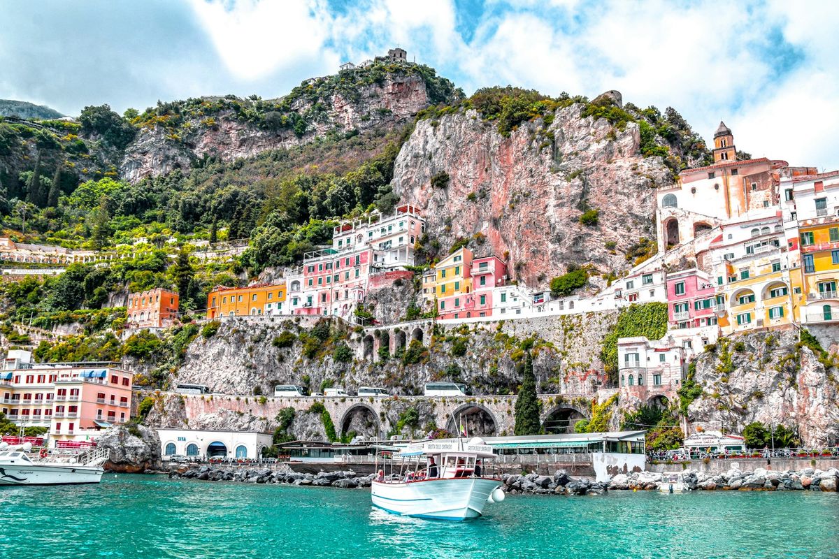 Boat on the water along the green mountainous Amalfi Coast, Italy
