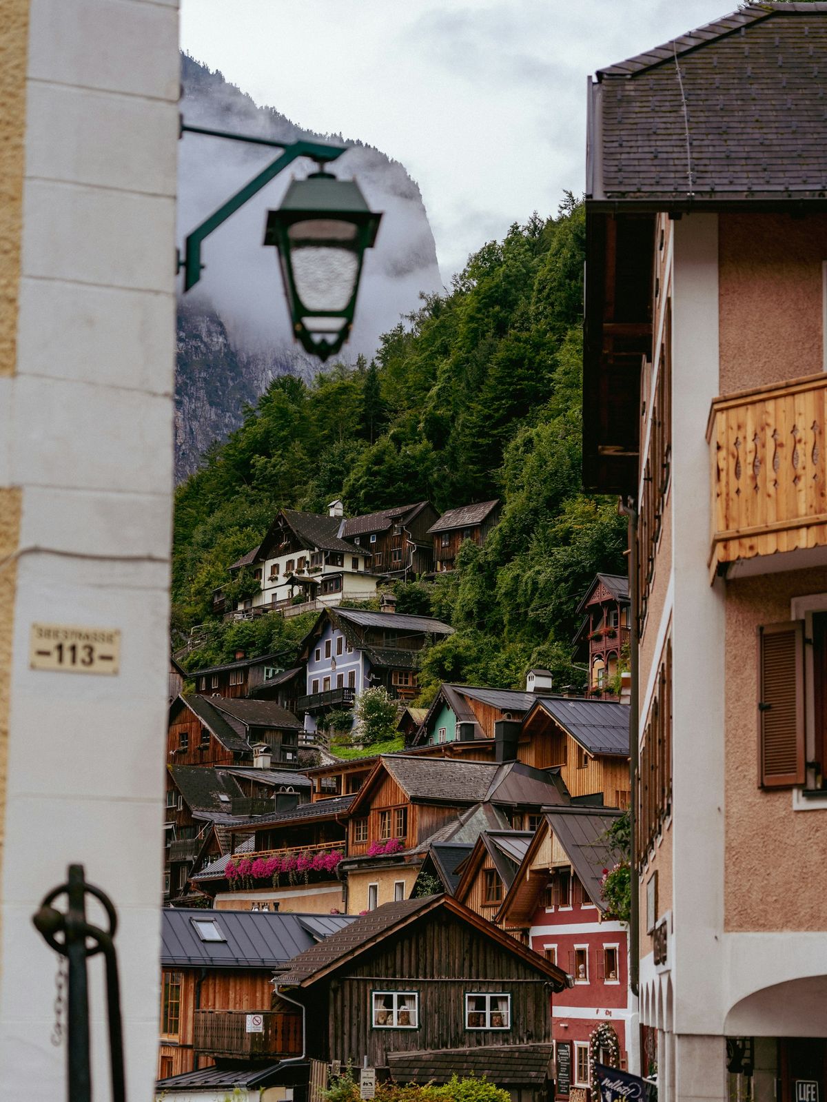 Hallstatt village street with wooden houses on the steep mountainside, Austria