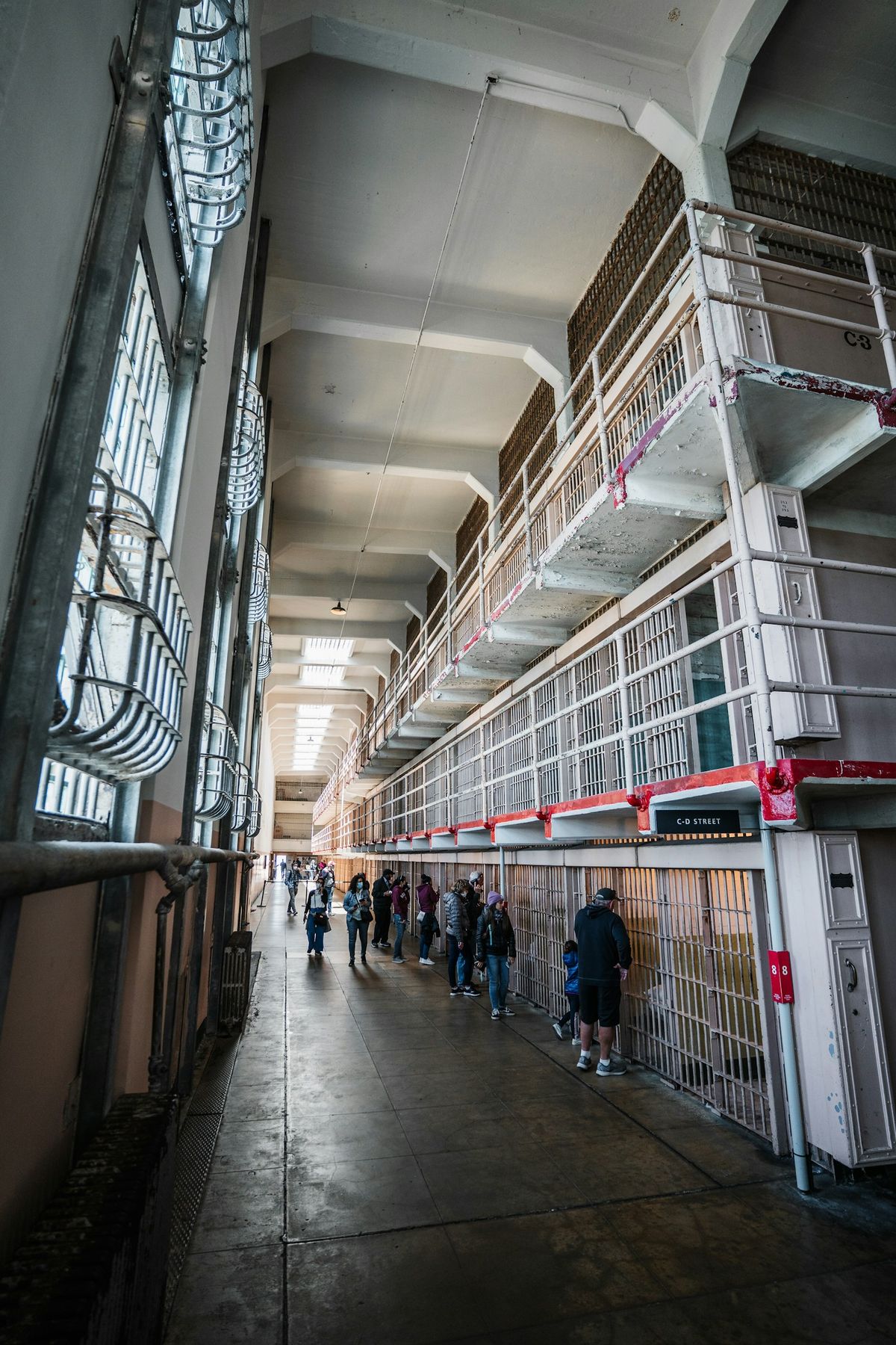 Visitors walking through a cell block hallway inside Alcatraz prison