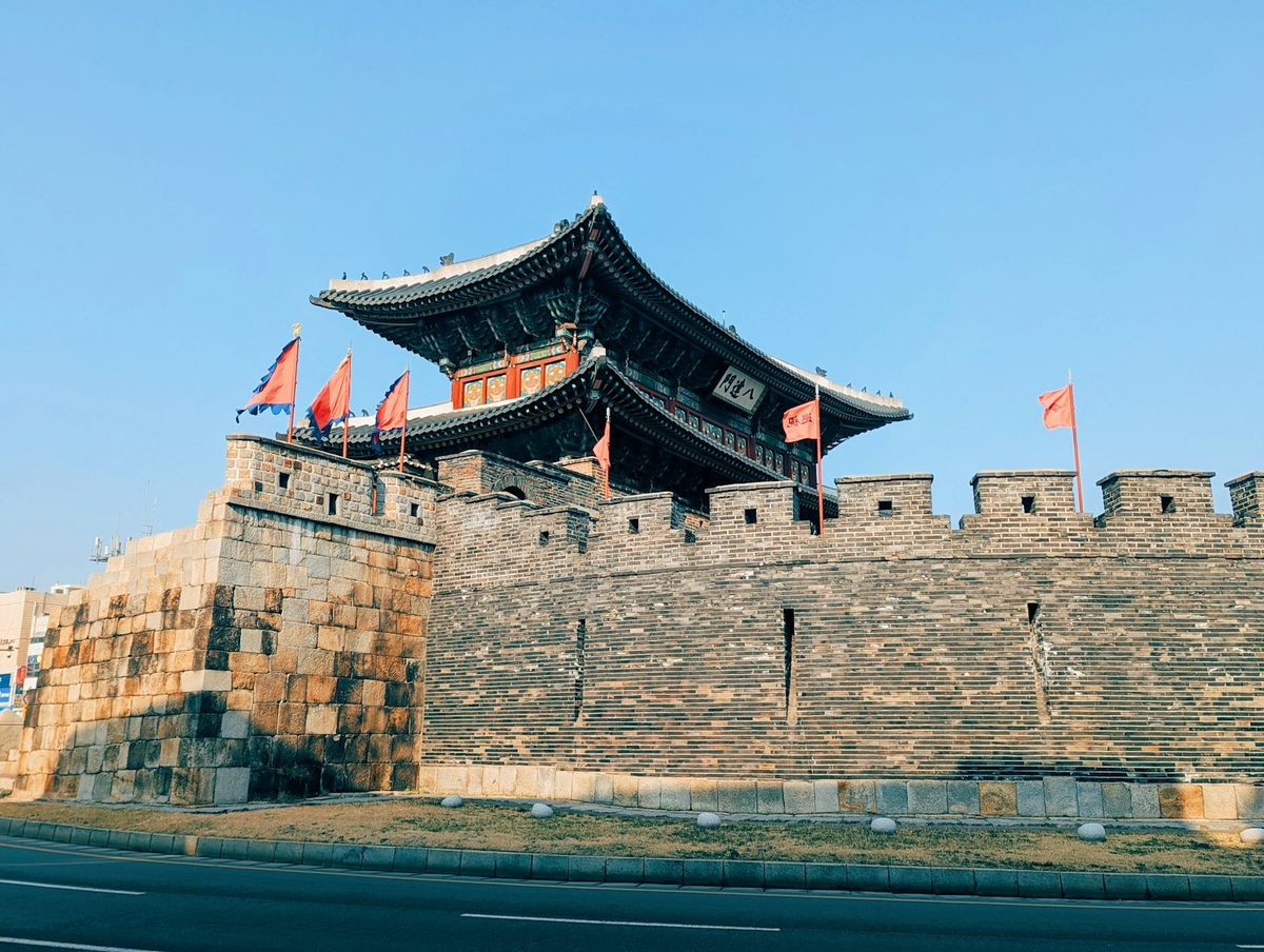 Hwaseong Fortress gate with red flags in Suwon, South Korea