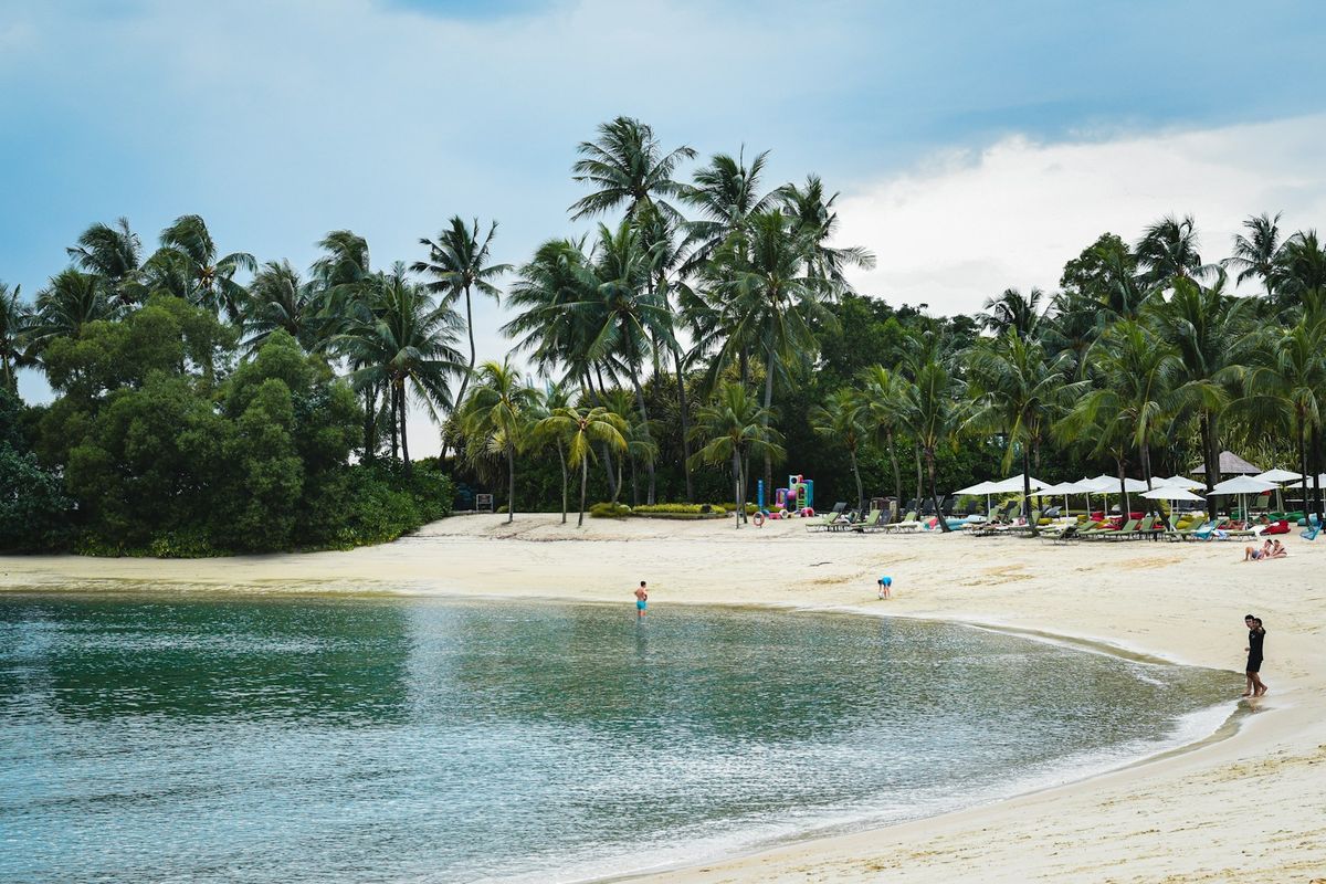 Palawan Beach with palm trees and umbrellas on Sentosa Island