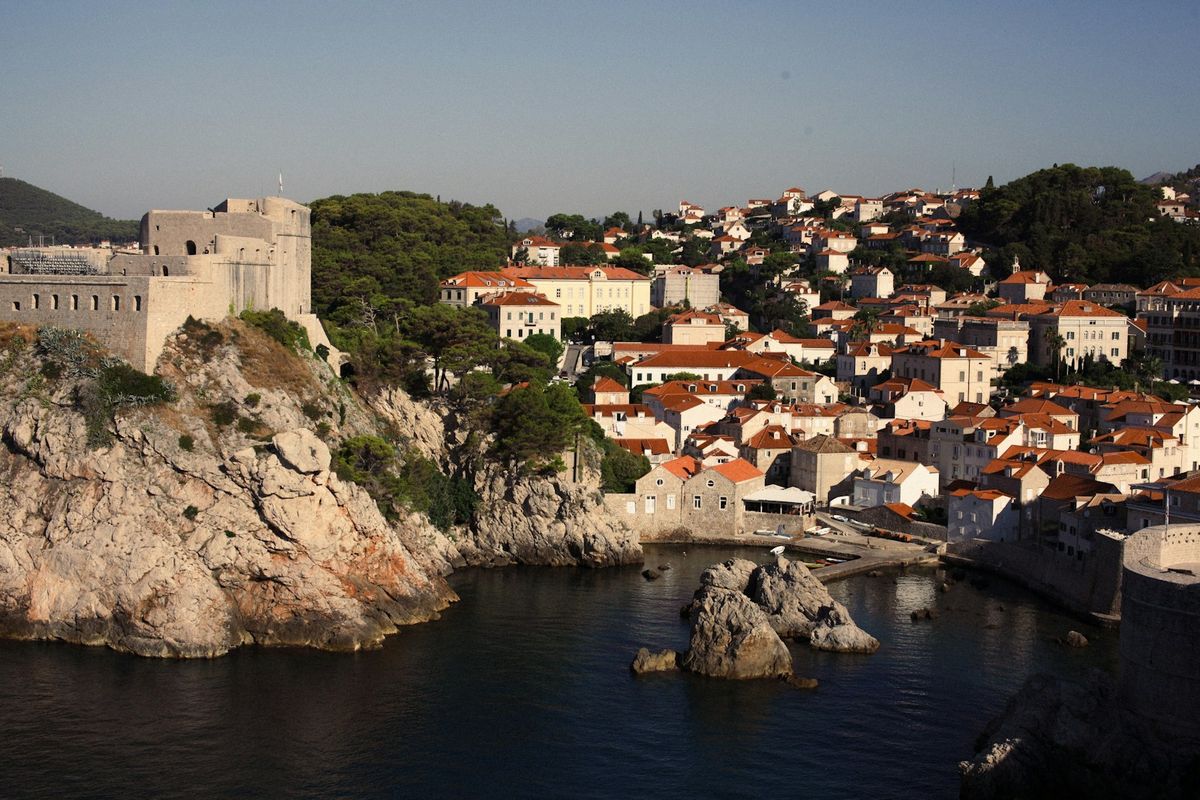 Aerial view of Dubrovnik old town walls and terracotta rooftops from clifftop