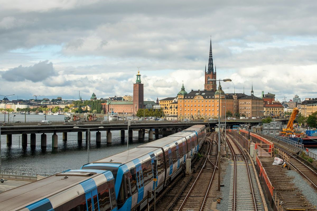 Train on tracks with city skyline in background in Sweden