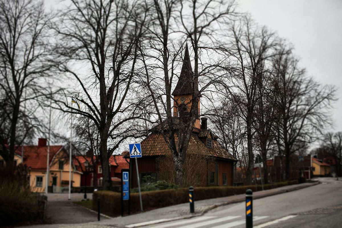 Small church with a steeple on a street corner in Sigtuna, Sweden