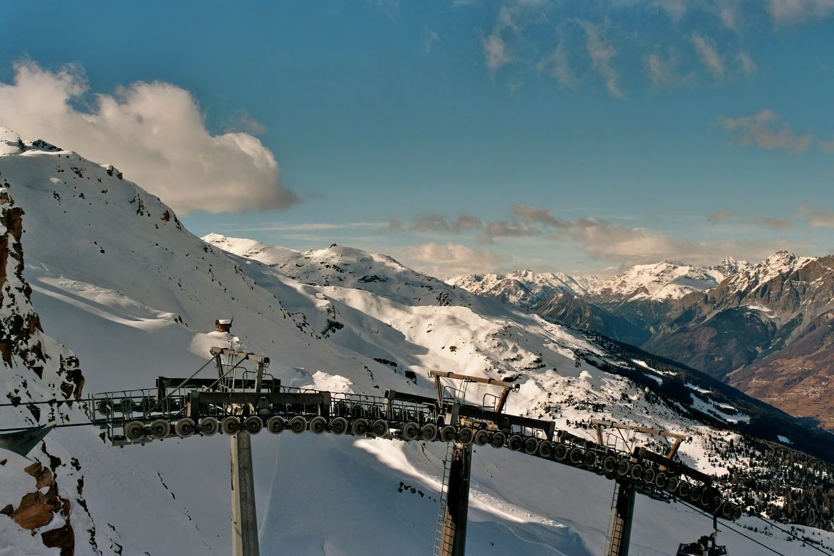 Cable car ascending a snow-covered peak in the Italian Alps