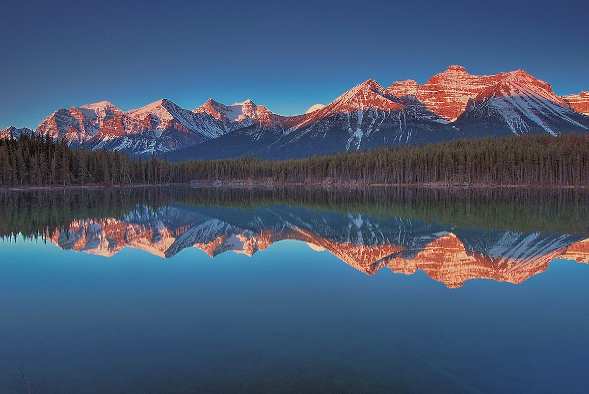 Mountain range reflected in a calm lake in the Canadian Rockies