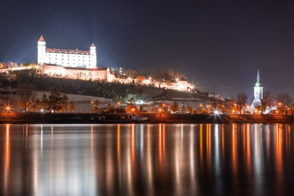 Bratislava Castle illuminated on a hill above the Danube river