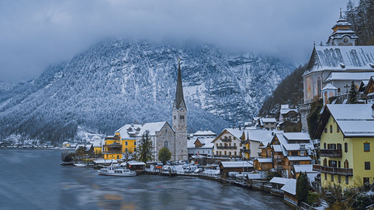 Snowy village with a church by the lake in Hallstatt, Austria