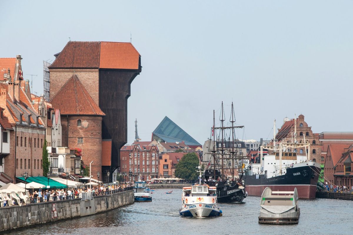 Boats on the Motlawa river beside the historic wooden crane in Gdansk, Poland